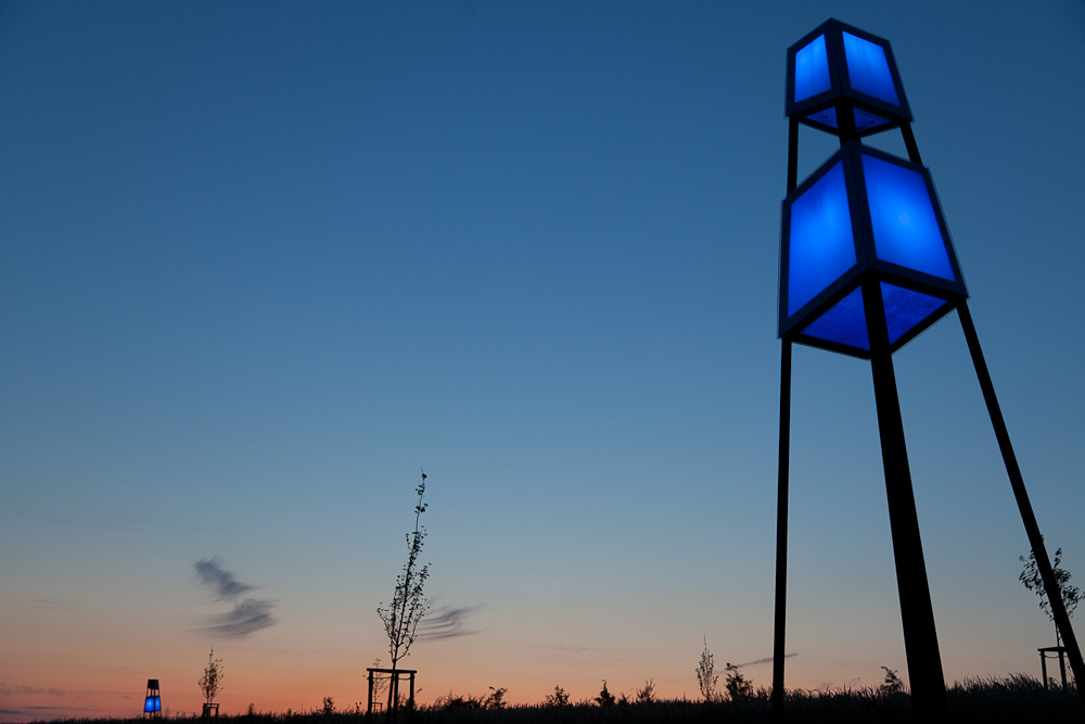 Neun blau schimmernde "Leuchttürme" aus Stahl und Plexiglas, die an das Fördergerüst der Zeche Monopol erinnern sollen, säumen den Weg auf die Halde.